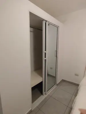 a glass closet in a white room with a bed at Cruce Caribeña in Boca Chica