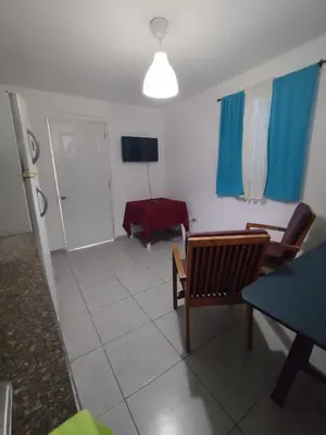 a living room with a table and chairs and a television at Cruce Caribeña in Boca Chica