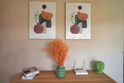 a shelf with a vase on a table with two pictures at Tropical Gem by the Sea in Sosúa