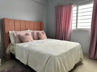 a bedroom with a large bed with pink pillows at Casa en la Autopista de San Isidro in Hainamosa