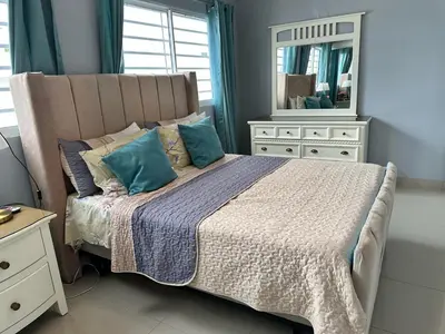 a bedroom with a bed with blue pillows and a mirror at Casa en la Autopista de San Isidro in Hainamosa
