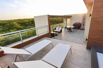 a balcony with white tables and chairs on a building at 504 New, Fantastic Rooftop with Private Jacuzzi in La Laguna