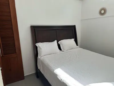 a bed with two white pillows in a bedroom at Hotel Appartements Hummingbird CABARETE in Cabarete