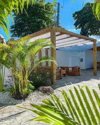 a wooden pergola in a yard with some plants at Hotel Appartements Hummingbird CABARETE in Cabarete