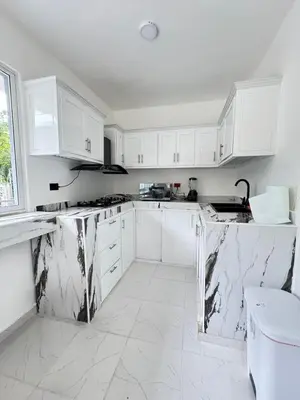 a kitchen with white cabinets and marble counter tops at villa el naciente in La Cuaba