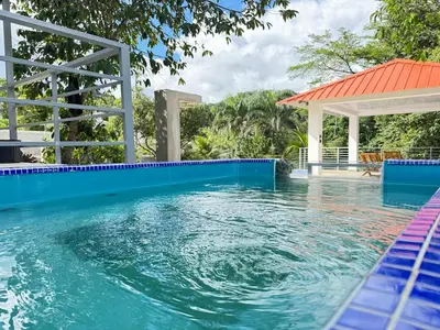 a swimming pool with a gazebo next to a swimming pool at villa el naciente in La Cuaba