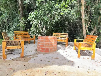 a group of wooden benches sitting in front of trees at villa el naciente in La Cuaba