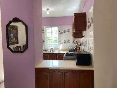 a kitchen with purple walls and a sink and a mirror at Brisa de mar BOCA CHICA, in Boca Chica