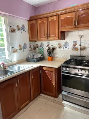 a kitchen with wooden cabinets and a stove top oven at Brisa de mar BOCA CHICA, in Boca Chica