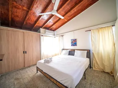 a bedroom with a bed with a wooden ceiling at Colonial 2BR Apartment 2mins walk to beach in Sosúa