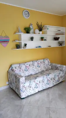 a couch in a living room with a clock on a wall at Caribe Home Dominicus Ginepro 3 in La Laguna