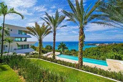 an exterior view of a resort with palm trees and a swimming pool at 5 mins from beach, Hilltop villa with pool in La Pared