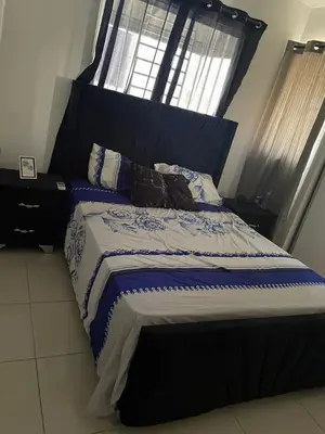 a bedroom with a large bed with a large window at Apartamento en ciudad Juan bosch con todas las amenidades in Los Paredones