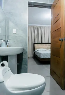a bathroom with a sink and a toilet and a bed at Caribey2 APT 3D1 in Las Terrenas