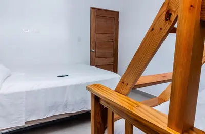 a bedroom with a bed and a wooden ladder at Caribey2 APT 3D1 in Las Terrenas