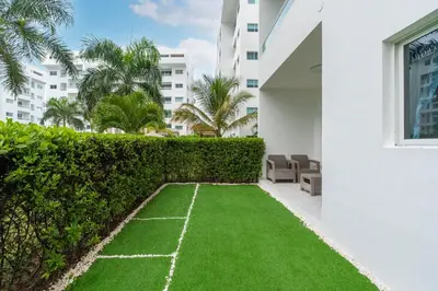 a garden with grass on the side of a building at Beach Escape -Pool Patio -Free Parking -Pets in Villas del Mar