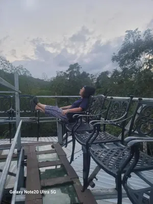 a woman sitting on a bench with her feet up at Rancho Salto Yanigua in El Valle