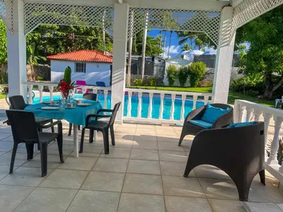 a patio with a table and chairs and a pool at Mango house bliss in Las Galeras