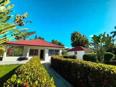 a house with a red roof and some bushes at Mango house bliss in Las Galeras
