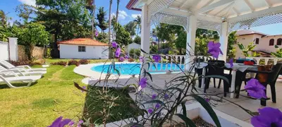 a patio with purple flowers next to a swimming pool at Mango house bliss in Las Galeras