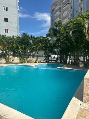 a blue swimming pool with palm trees and buildings at Amalia Lucero in Mendoza