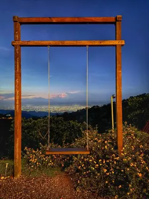 a swing sitting on top of a hill with flowers at Pure Nature - Eco-lodge in the Mountains! in La Búcara