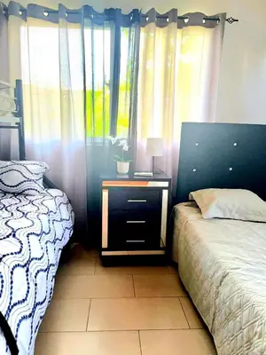 a bedroom with a bed and a nightstand and a window at Modern Apartment, Juan Dolio Beach, BlueSea Tower in Villas del Mar