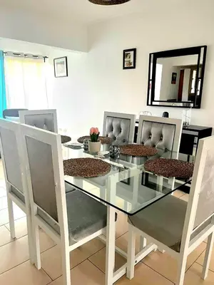 a dining room with a glass table and chairs at Modern Apartment, Juan Dolio Beach, BlueSea Tower in Villas del Mar
