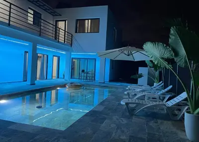 a swimming pool with two chairs and an umbrella at Apartamento Entre Playas 3 - 2 pax, 4 min de la playa in Las Galeras