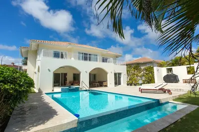 a villa with a swimming pool in front of a house at Stunning 4 BR Luxury Villa in Punta Cana
