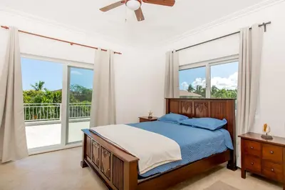 a bedroom with a bed and large windows at Stunning 4 BR Luxury Villa in Punta Cana
