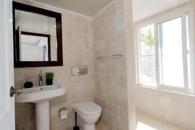 a bathroom with a toilet and a sink and a mirror at Stunning 4 BR Luxury Villa in Punta Cana