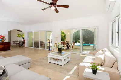 a living room with white furniture and a ceiling fan at Stunning 4 BR Luxury Villa in Punta Cana
