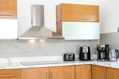 a kitchen with wooden cabinets and a stove top oven at Stunning 4 BR Luxury Villa in Punta Cana