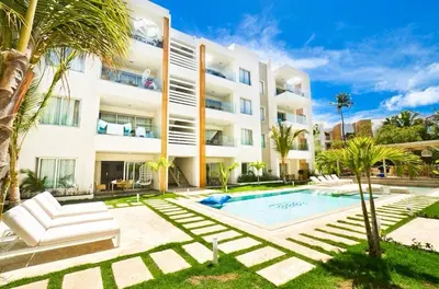 an apartment building with a swimming pool and palm trees at Apartamento en punta cana close to the beach in Punta Cana