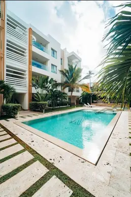 a swimming pool in front of a building at Apartamento en punta cana close to the beach in Punta Cana