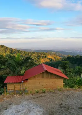 a small wooden building with a red roof on a hill at Mountain refuge - Cabin with wonderful views! in La Búcara