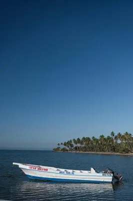 a boat in the water with an island in the background at La Anshihi in Las Terrenas