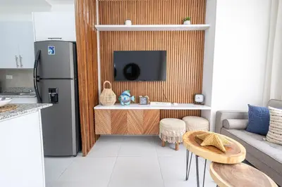 a kitchen with a refrigerator and a table in a room at Rosa s Hidden Gem beach wifi in Los Corrales