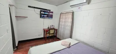a room with a bed and a table and a tv at Apartamento Mirador de La ciudad in Jarabacoa