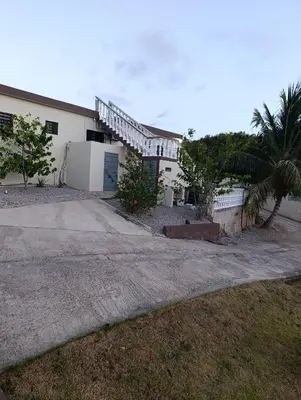 a white house with a palm tree and a driveway at Apart hotel Costa Verde#7 con cama Queen in Las Galeras