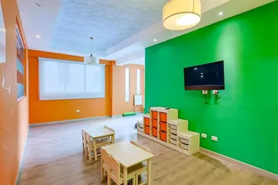 a room with a green wall with a table and chairs at Elegant Centric Apt Near all in Santo Domingo