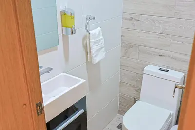 a small bathroom with a toilet and a sink at Elegant Centric Apt Near all in Santo Domingo
