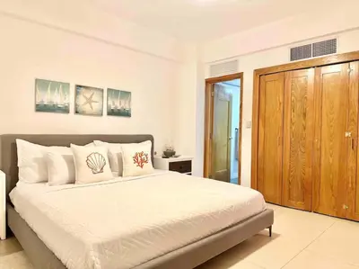 a bedroom with a large bed and a wooden closet at Cozy Beach Condo Great Views in Guayacanes