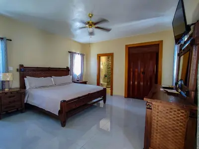 a bedroom with a bed and a ceiling fan at Sol, playa y arena, Casa cerca de la playa in San Felipe de Puerto Plata