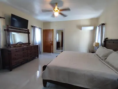 a bedroom with a bed and a ceiling fan at Sol, playa y arena, Casa cerca de la playa in San Felipe de Puerto Plata