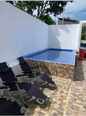 a group of chairs sitting next to a swimming pool at Apart-hotel Central in Las Terrenas