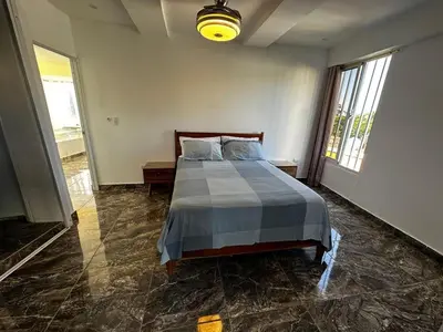 a bedroom with a bed and a large window at Apart-hotel Central in Las Terrenas