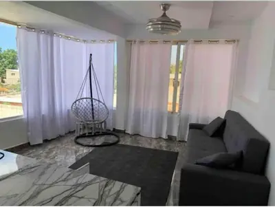 a living room with a couch and a large window at Apart-hotel Central in Las Terrenas