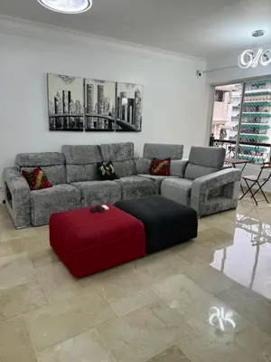 a living room with a couch and a red ottoman at Torre DOÑA EVA in Santo Domingo